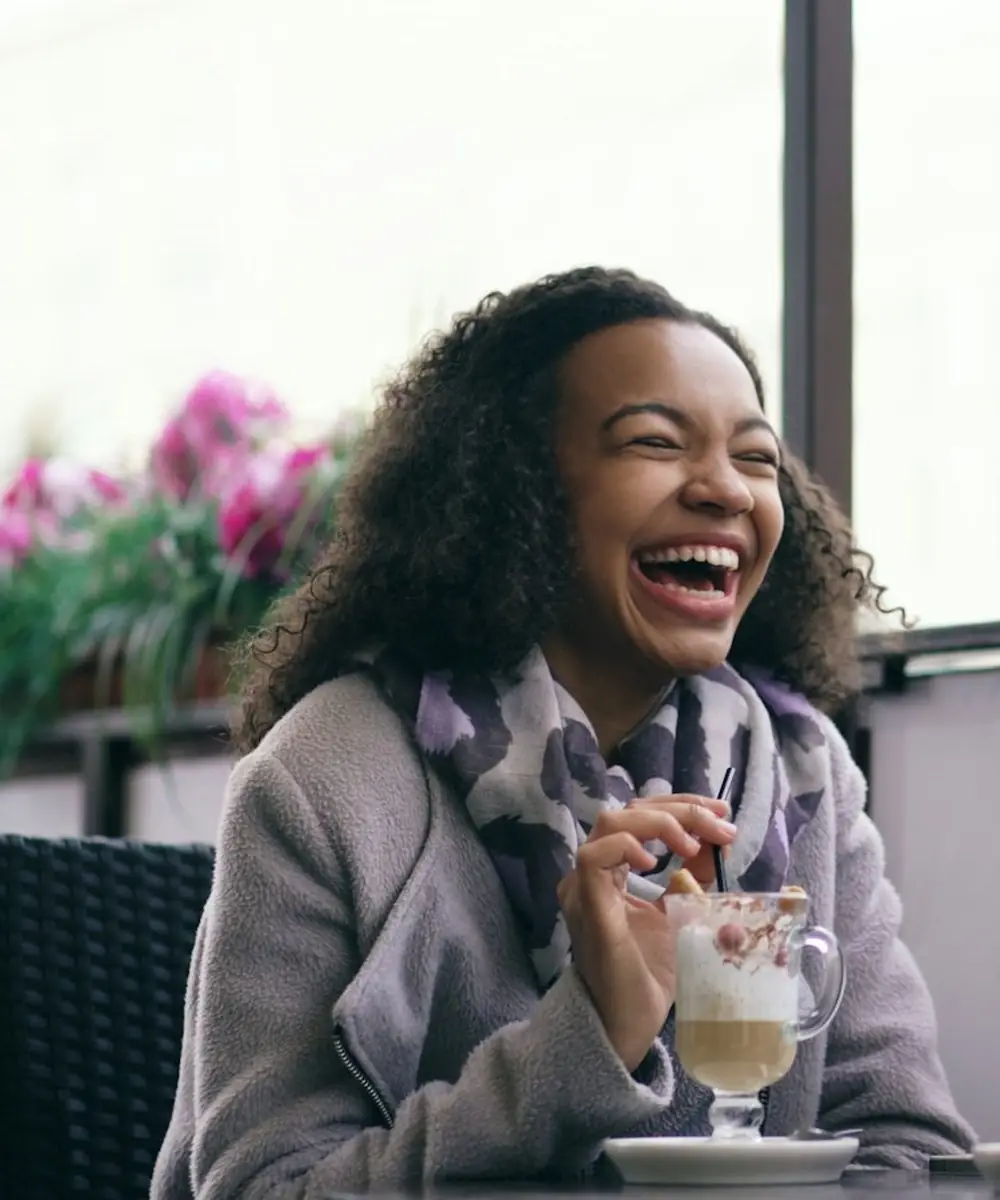 Two friends laughing over coffee