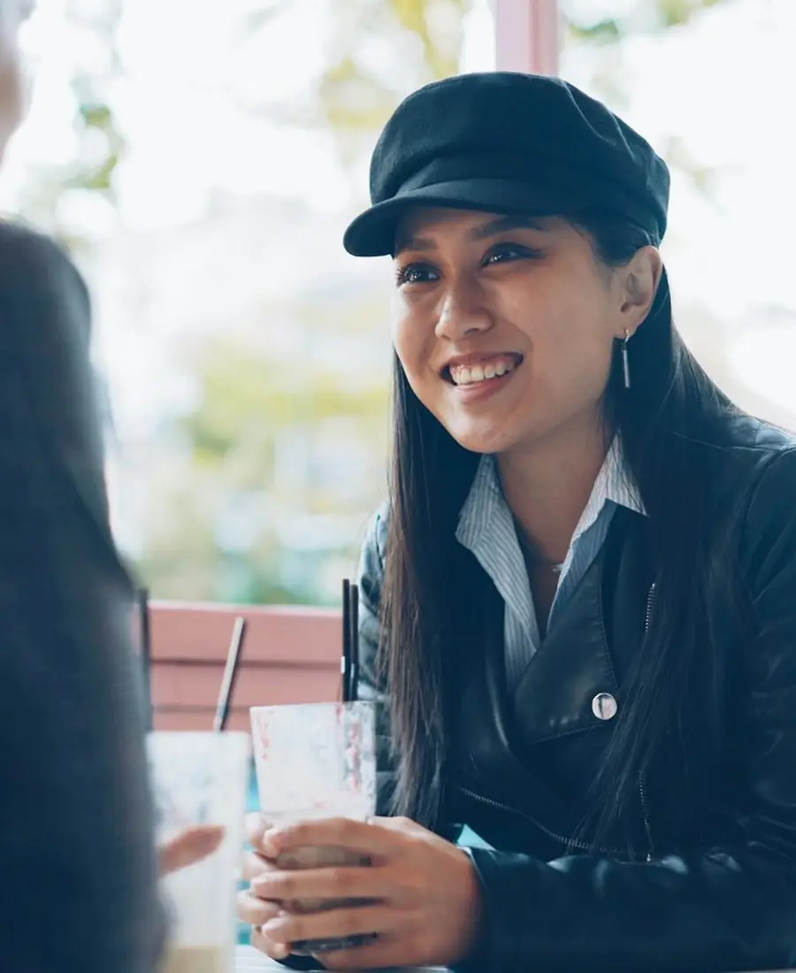 Two friends talking over drinks at a café